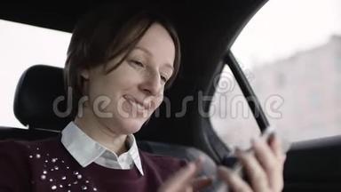 穿着白色衬衫和栗色毛衣的棕色头发的女人坐在车里，微笑着输入信息